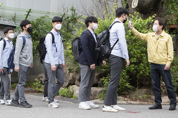 韩国首尔景福高等学校的学生在入校前接受体温检测。新华社资料
