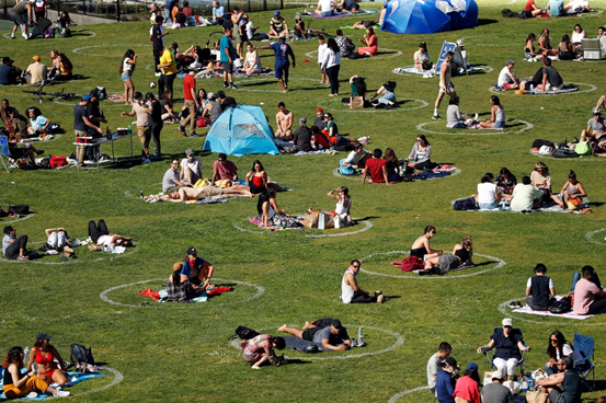 图：公园里呆在社交隔离圈内的人们