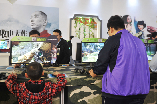 2013年10月13日，北京，在第十一届中国国际网络文化博览会的展区里，两个年龄差异显著的观众正在试玩网络游戏。视觉中国供图