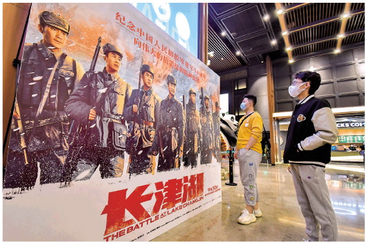 　　▲2021年10月7日，两名年轻人在北京一家影院观看电影《长津湖》的海报。　 新华社记者李欣摄